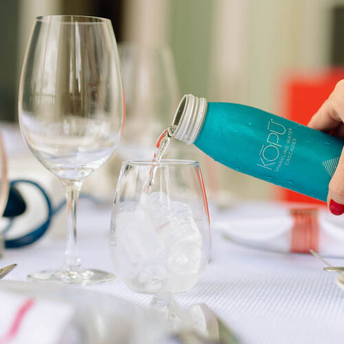 KOPU sparkling water aluminum can being poured into glass.
