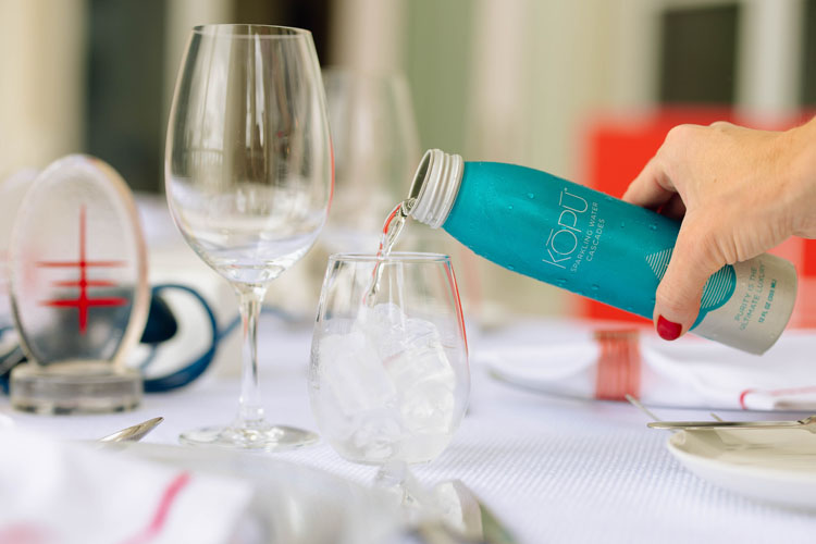 KOPU sparkling water aluminum can being poured into glass.