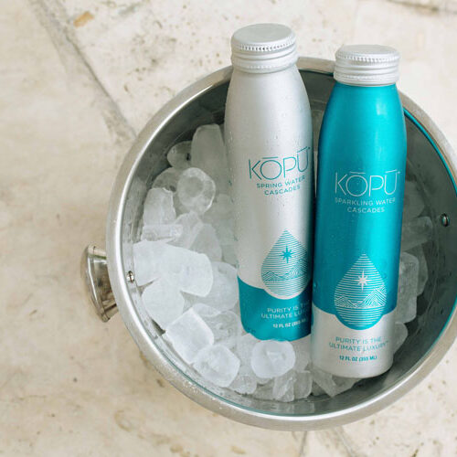 KOPU sparkling and spring water cans in bucket of ice.