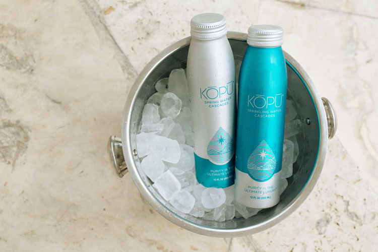 KOPU sparkling and spring water cans in bucket of ice.